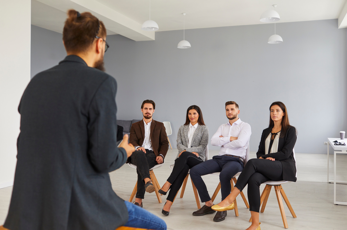 Group of Young People Listening to Experienced Business Trainer or Personal Growth Coach